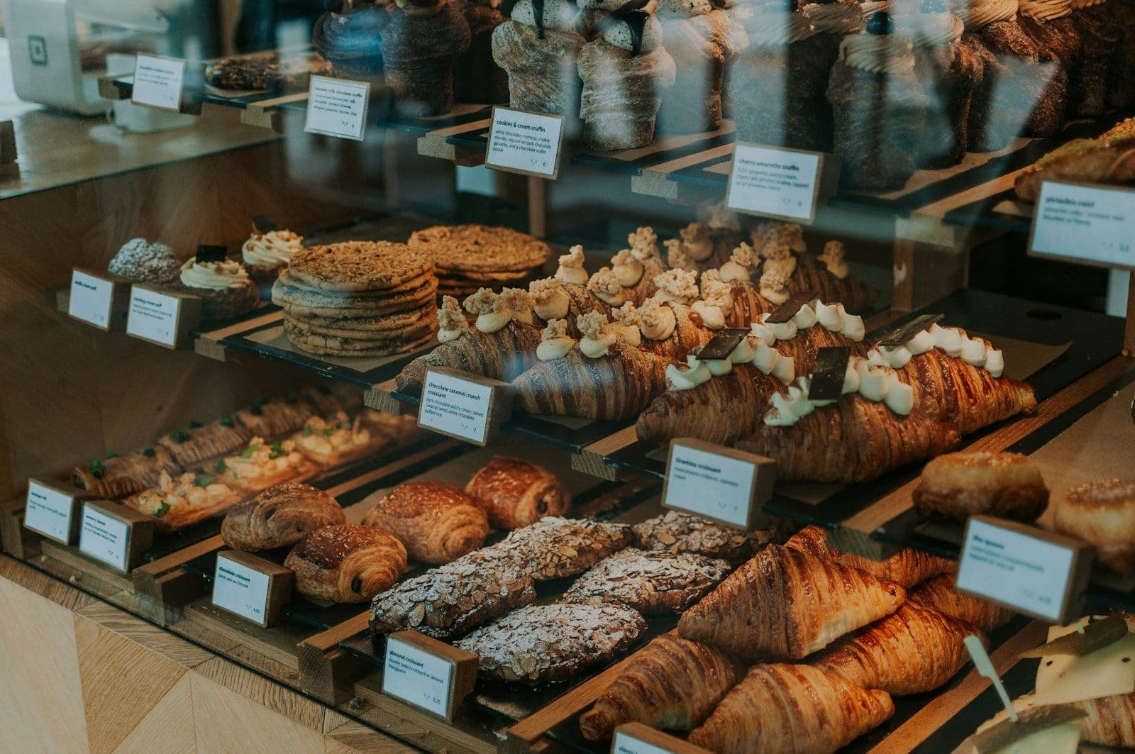 Bakery display case filled with croissants and pastries