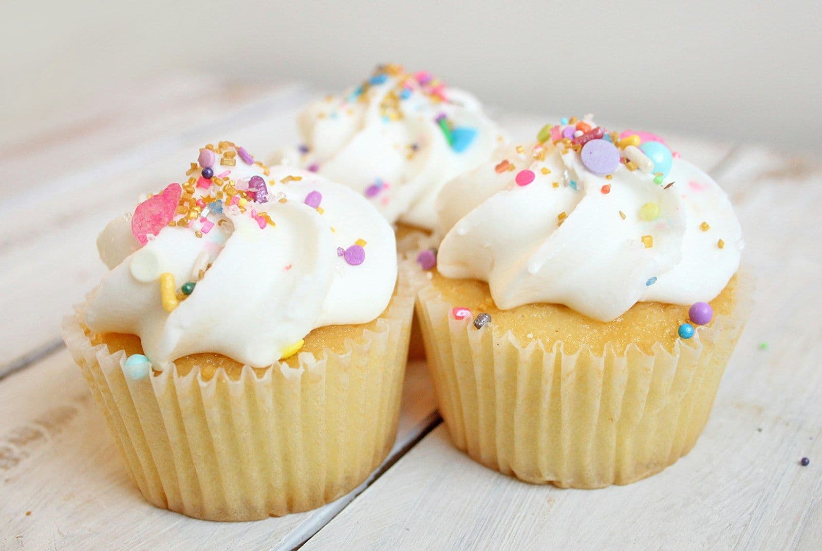 Vanilla cupcakes with frosting and sprinkles