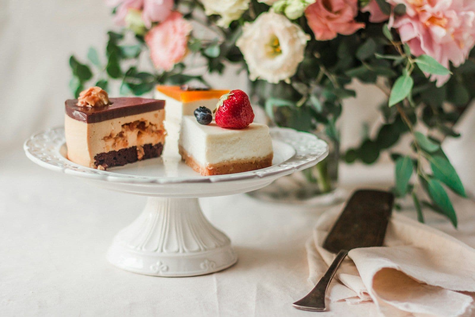 Slices of layered cake on a white cake stand